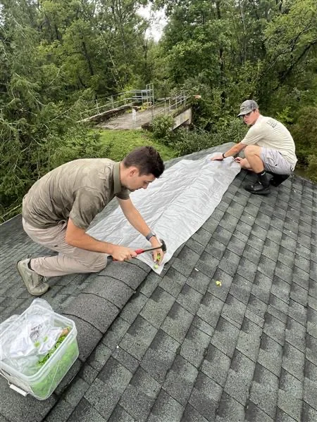 Roofing crew working on a shingle roof