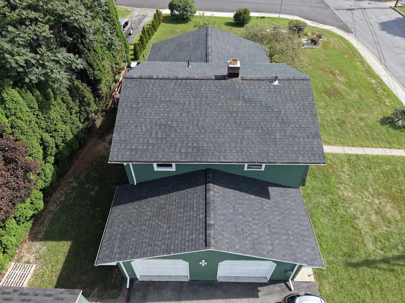 Rear view of a green home with dark shingles