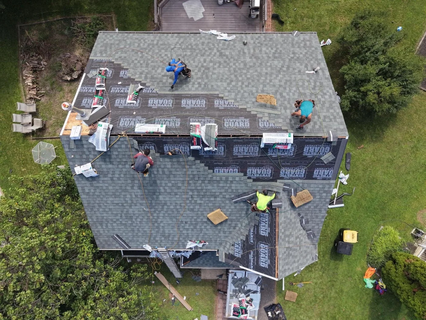 Roofing crew working on a roof seen from above