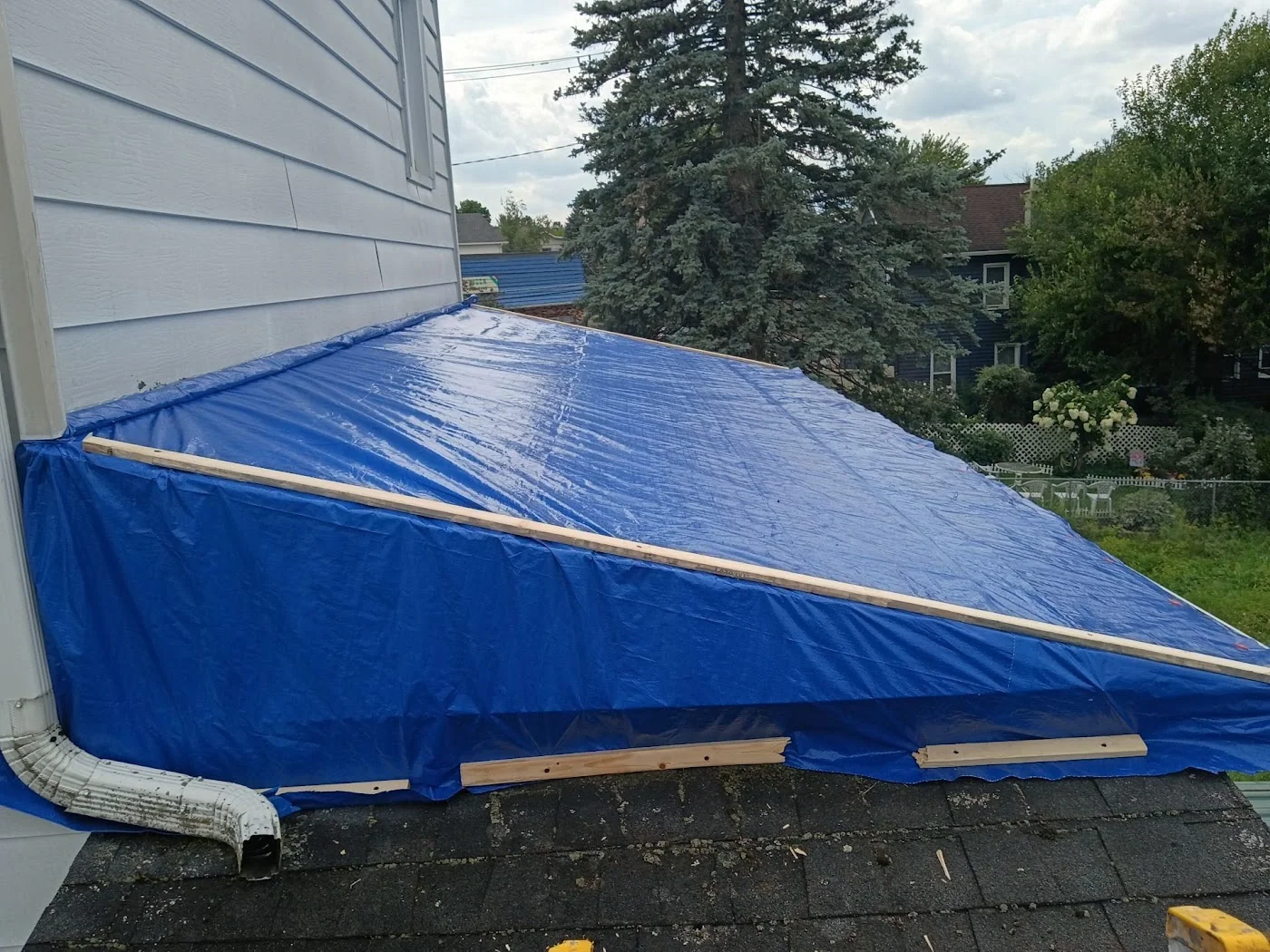 Side view of a tarp over a lower roof