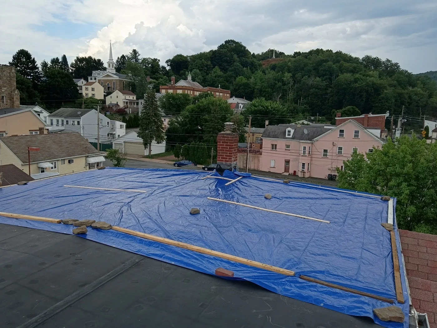 Another view of a blue tarp on a low-slope roof